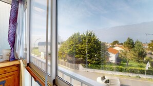 Ett fönster med utsikt över ett bostadsområde, med hus och träd.