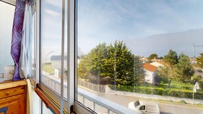 Ein Fenster mit Blick auf eine Wohngegend, einschließlich Häuser und Bäume.
