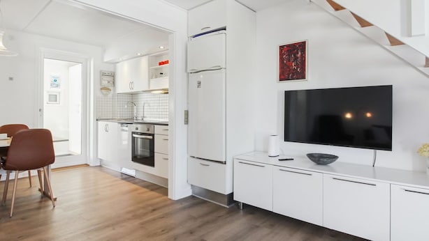 A modern kitchen with white cabinets, a built-in oven, and a large TV on a white console. - "Amlethus" - 2.3km from the sea by Interhome (Rømø)