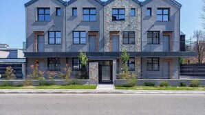 A modern multi-story building with a symmetrical facade, large windows, and a central entrance. - Flower Residence - Appartamento Hibiscus (Lissone)