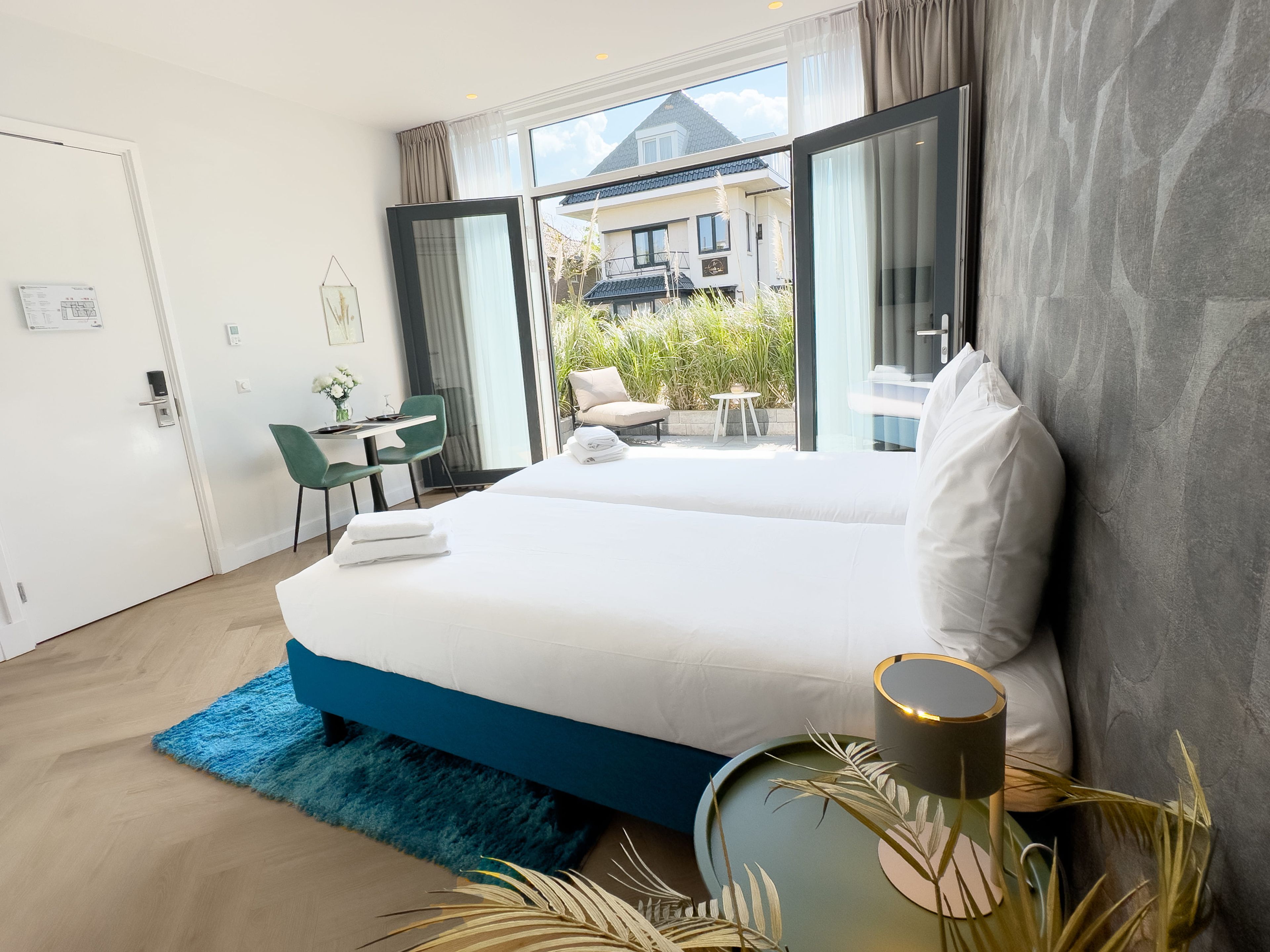 Une chambre d’hôtel moderne avec un grand lit, un bureau et une vue sur l’extérieur.