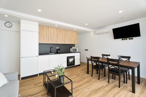 A modern kitchen with white cabinets, a wooden countertop, and a built-in microwave. - Vacation Apartment 'Ale Deluxe Home' with Sea View, Wi-Fi and Air Conditioning (Santiago del Teide)