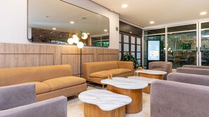 A modern lounge area with sofas, round coffee tables, and a large mirror. - Poblado de Alejandr a - 1201 (Medellín)