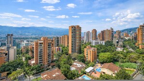A high-rise residential area with multiple apartment buildings, surrounded by greenery and a clear sky. - Poblado de Alejandr a - 1201 (Medellín)