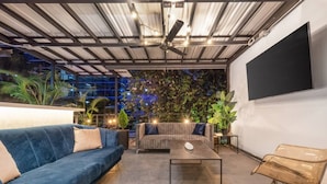 An outdoor seating area with a blue sofa, a grey sofa, a coffee table, and a chair. - Casa Madera Parque Lleras With Private Jacuzzi (Medellín)