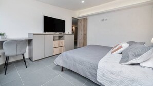 A modern bedroom with a bed, a desk, a chair, and a TV. - Oslo 703 in Medell n (Medellín)