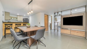 A modern kitchen with a dining area, a built-in TV, and a staircase leading to another level. - Oslo 703 in Medell n (Medellín)