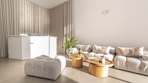 A modern living room with a sofa, ottoman, and two wooden coffee tables. - Metropolitan Living - 515a (Medellín)