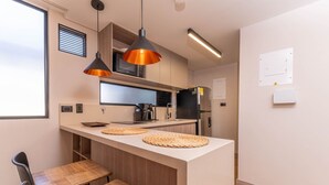 A modern kitchen with wooden countertops, a built-in microwave, and a coffee machine. - Jatisa 502 in Medell n (Medellín)