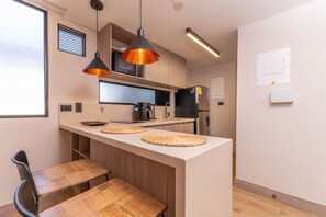 A modern kitchen with wooden countertops, a built-in microwave, and a coffee machine. - Jatisa 502 in Medell n (Medellín)