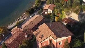 Vista aérea de uma área residencial com casas, uma estrada e um corpo d'água.