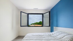 A bedroom with a bed, a window, and a view of greenery outside. - Relaxation & Serenity in Coulounieix-Chamiers – House with Pool and Spa (Coulounieix-Chamiers)