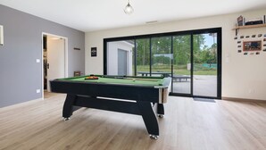 A modern indoor pool table with a clear view to the outdoors. - Relaxation & Serenity in Coulounieix-Chamiers – House with Pool and Spa (Coulounieix-Chamiers)
