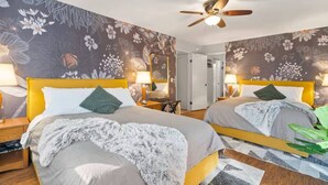A hotel room with two beds, a ceiling fan, floral wallpaper, and a mirror. - Serene Creek Escape | SPA•Arcade•Yosemite•14 guest (Sonora)