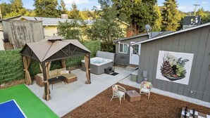 A backyard with a hot tub, outdoor seating, a pergola, and a mural. - Family Game Retreat|Spa•Arcade•Pickleball•Yosemite (Sonora)