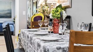 A dining table set with plates, wine glasses, and a vase with flowers. - Family Game Retreat|Spa•Arcade•Pickleball•Yosemite (Sonora)