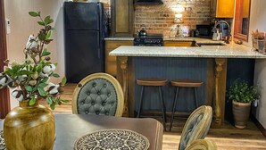 Una cucina moderna con parete in mattoni, soffitto in legno e luci a sospensione.