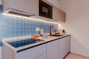 Eine moderne Küche mit Einbauherd, Mikrowelle und Spüle.