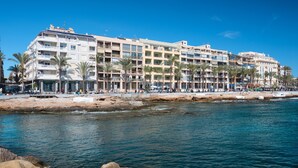 Ein Hotel an der Küste mit mehreren Etagen, Balkonen und einer Strandpromenade.