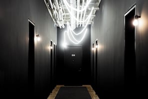A hallway with a modern light fixture, a door labeled '306', and a carpeted floor. - ALPAMI Glockenbach  (Munich)
