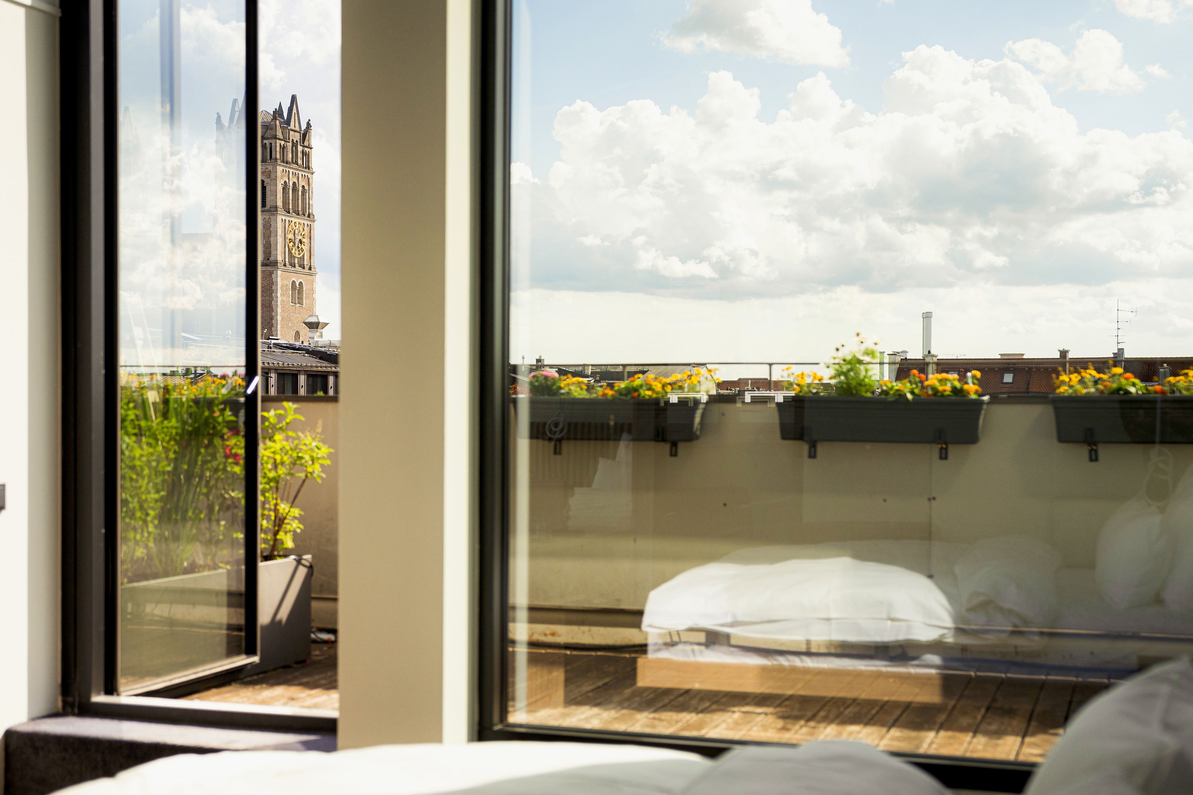 Una habitación con un ventanal grande que da a un paisaje urbano, incluyendo una torre destacada.