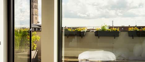 A room with a large window overlooking a cityscape, including a prominent tower.
