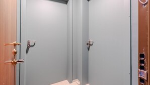 A hallway with two closed doors, each with a keyhole and a handle. - This large studio apartment is ideally located for exploring Turin, with easy access to the subway, allowing you to reach the city center in just a few minutes and the lively San Salvario neighborhood in even less time. Just steps from Parco del Po, the  (Turin)