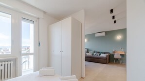 A modern hotel room with a large bed, a balcony, a sitting area with a sofa, and a desk. - This large studio apartment is ideally located for exploring Turin, with easy access to the subway, allowing you to reach the city center in just a few minutes and the lively San Salvario neighborhood in even less time. Just steps from Parco del Po, the  (Turin)