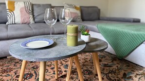 A round table with a plate and two glasses, a small potted plant, and a candle on a patterned rug. - The Felix Piyat (Bourges)