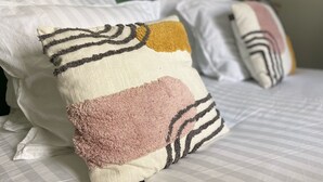 A bed with striped bedding and multiple pillows. - The Felix Piyat (Bourges)