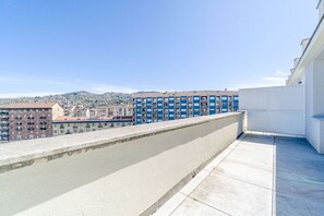 A rooftop terrace with a view of a cityscape, including multi-story buildings and a distant hill. - A comfortable studio apartment with a terrace offering all the amenities needed to accommodate up to three guests. Conveniently located, very close to the metro, it allows you to reach the city center in just six minutes and the San Salvario neighborhood (Turin)