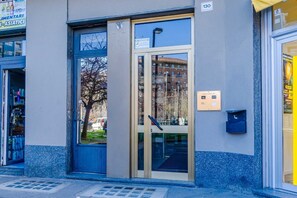 A building entrance with a glass door, a mailbox, and a sign indicating the entrance. - Elegant studio apartment in a very convenient location, right in front of the metro station: in just 6 minutes you'll be downtown, and even faster to the lively San Salvario neighborhood. The apartment is just steps from the Po River Park, the Lingotto e (Turin)