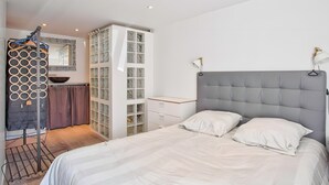 Ein Schlafzimmer mit Bett, Kleiderschrank, Spiegel und Fenster.