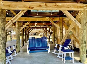 A covered outdoor seating area with wooden beams and benches. - THE SALTY FOX- 3bd/2bth w/ golf cart. CLOSE TO BEACH TheKeys@OceansideVillage (Surfside Beach)
