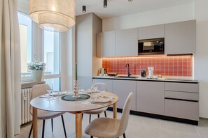 A modern kitchen with a dining area, featuring a large window, a pendant light, and a microwave. - A welcoming and functional studio, conveniently located in a area with excellent metro access, perfect for reaching the city center in just a few minutes and easily traveling to San Salvario. The location is also ideal for those needing to reach the Po R (Turin)
