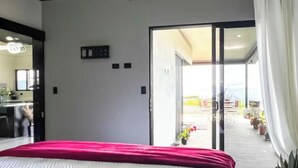 A bedroom with a bed, a sliding glass door to an outdoor area, and a small desk with a chair. - House Airy Luxury+WiFi+Amazing View At Alajuela CR (Provincia de Alajuela)