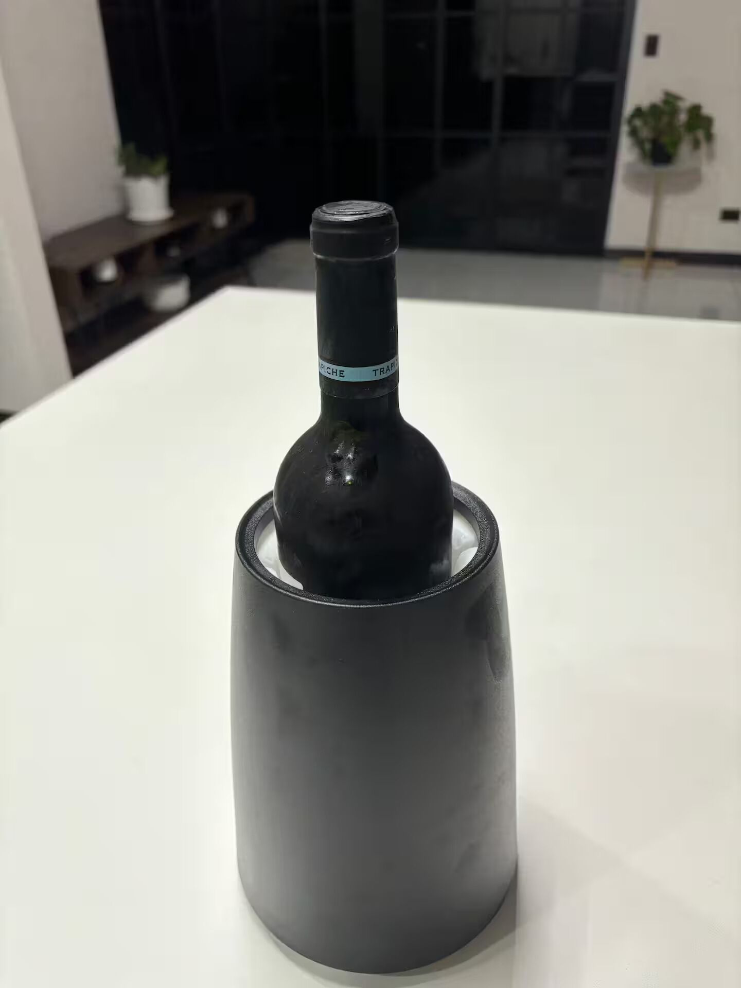 A bottle on a white table in a room with a modern design.