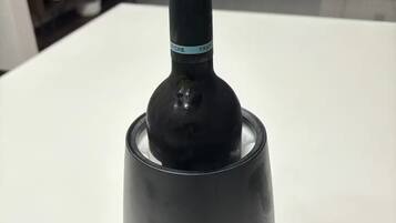 A bottle on a white table in a room with a modern design.