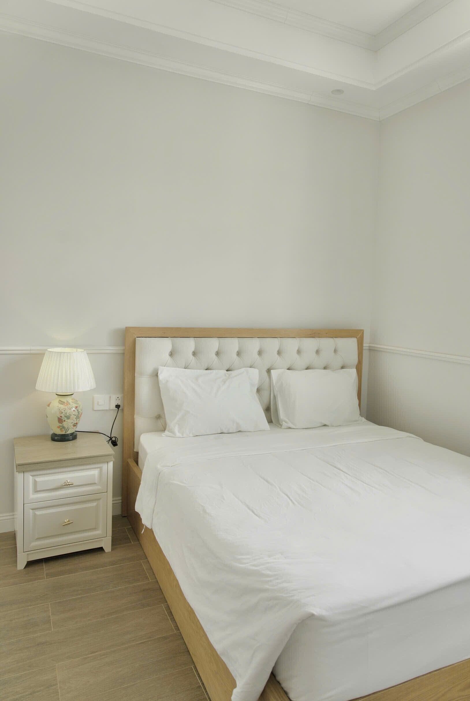 Un dormitorio con una cama, una mesita de noche y una lámpara.