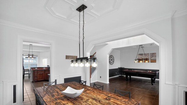 A spacious dining area with a wooden table, chairs, a chandelier, and a pool table. - Spacious 4BR Retreat |Pool Table| Firepit & Hottub (Kyle)
