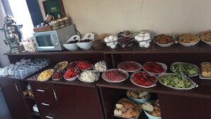 A buffet with various food items and a microwave on the counter. - Pembe Köşk Old City Center Sultanahmet (İstanbul)