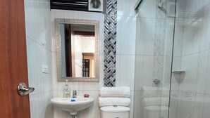 Une salle de bain avec des toilettes, un lavabo et une douche.