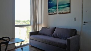 Een kamer met een bank, een tafel en uitzicht op het omliggende landschap.