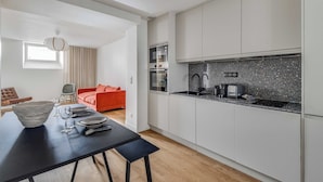 Eine moderne Küche mit weißen Schränken, einer Granit Arbeitsplatte und einem Einbauofen.