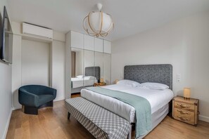 A bedroom with a bed, bedside table, bench, wardrobe, and a TV. - Spacious Apartment a/c 1br/4p - Notre-dame (Paris)