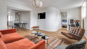 Ein modernes Wohnzimmer mit Sofa, Couchtisch und Fernseher.