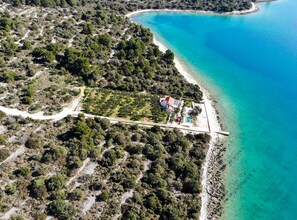 An aerial view of a coastal property with a house, a swimming pool, and a beach. - Villa Renata (Okrug)