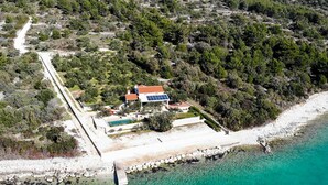 An aerial view of a coastal property with a house, a swimming pool, and a boat dock. - Villa Renata (Okrug)
