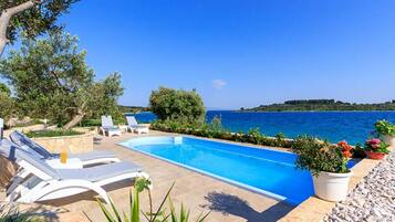 Villa (FourBedroom Beachfront Villa with Poo) | Alberca al aire libre | Alberca al aire libre por temporada y sombrillas en la alberca