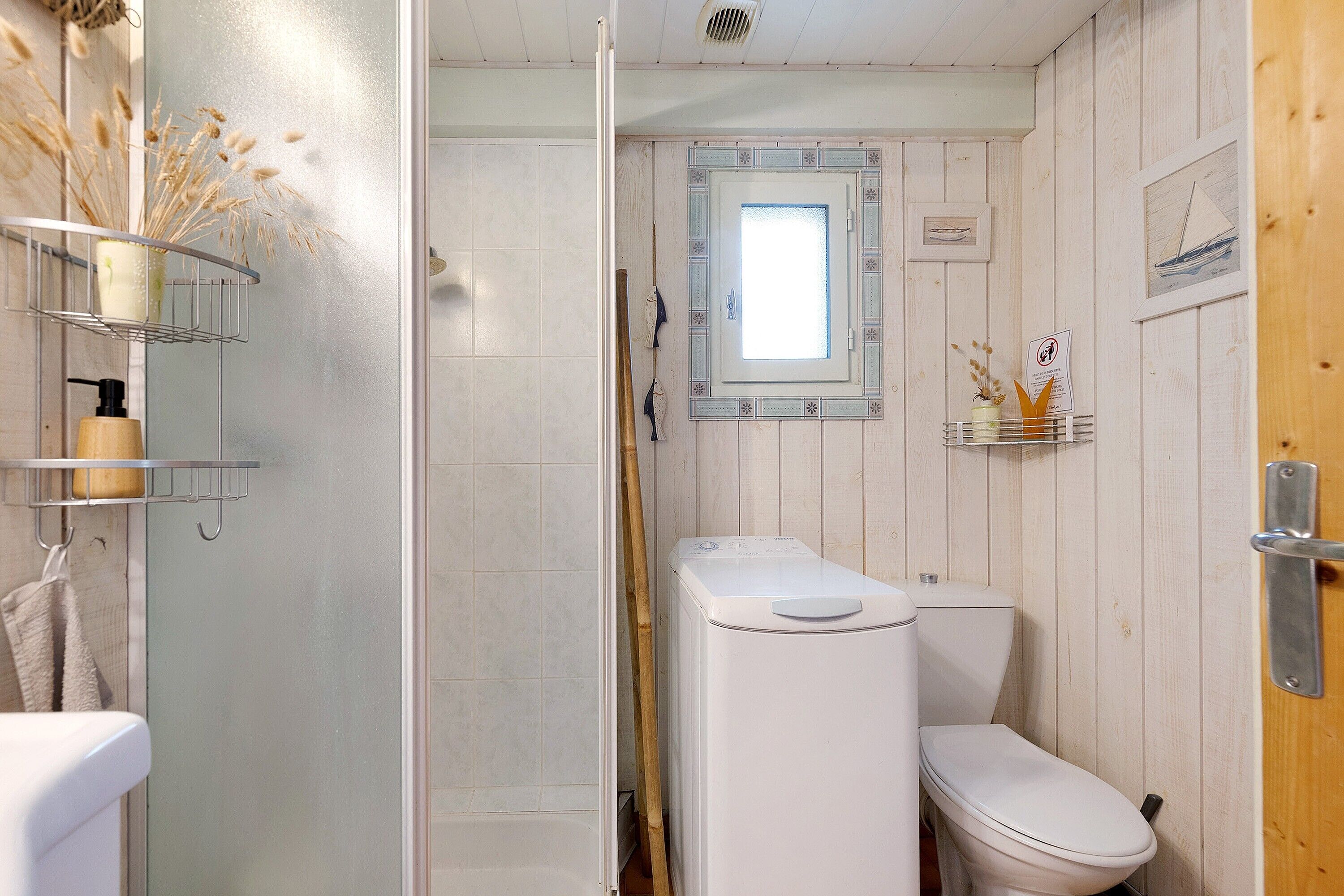 A bathroom with a toilet, a shower, and a sink with a mirror above it.
